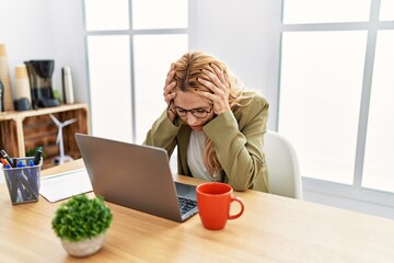 Poster - Beautiful blonde woman working at the office with laptop suffering from headache desperate and stressed because pain and migraine. hands on head.