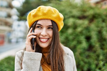 Wall Mural - Young hispanic girl smiling happy talking on the smartphone at the city.