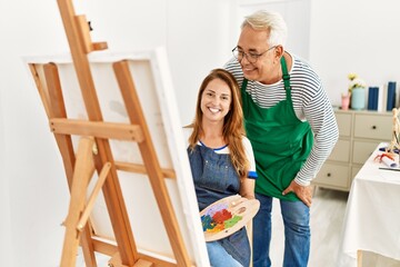 Poster - Two middle age artists smiling happy painting at art studio.