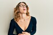 © Krakenimages.com - Young caucasian woman wearing business shirt and glasses with hand on stomach because nausea, painful disease feeling unwell. ache concept.