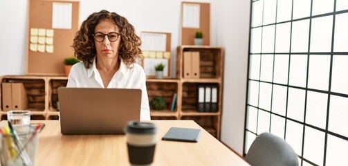 Sticker - Middle age hispanic woman working at the office wearing glasses skeptic and nervous, frowning upset because of problem. negative person.