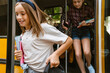 © Drobot Dean - Multiracial pupils smiling while getting off school bus