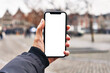 © Krakenimages.com - Hand of man holding smartphone at street