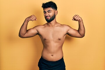 Poster - Arab man with beard wearing swimwear shirtless showing arms muscles smiling proud. fitness concept.