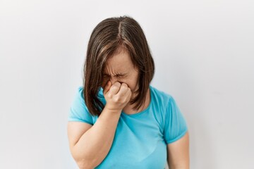 Sticker - Young down syndrome woman standing over isolated background tired rubbing nose and eyes feeling fatigue and headache. stress and frustration concept.