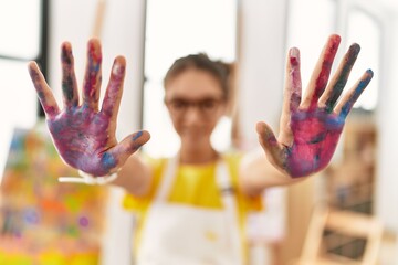 Poster - Adorable girl smiling confident showing painted palm hands at art studio