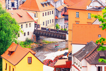 Summer cityscape - top view of the Old Town of Cesky Krumlov and the Vltava river with bridge through it, Czech Republic