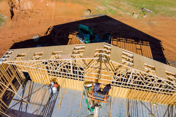 Wall Mural - Roofer working with framing installing the roof truss system