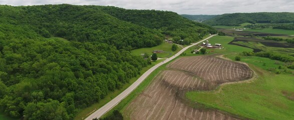 Wall Mural - Road Through Rolling Green Hills in Wisconsin Farmland (Drone)