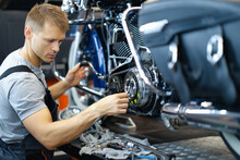 Master Repairman Repairing Motorcycle In Workshop With Tools