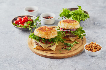 Wall Mural - Two burgers with veal cutlet and herbs on wooden cutting board