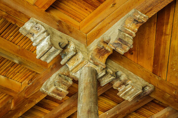 Wall Mural - Close-up view of the top of the column in Juma Mosque, Khiva, Uzbekistan. Wooden construction of ceiling's overlap is made in ancient Central Asian tradition