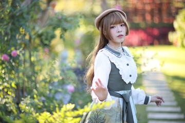 A beautiful woman in lolita dress in garden background Japanese street fashion portrait