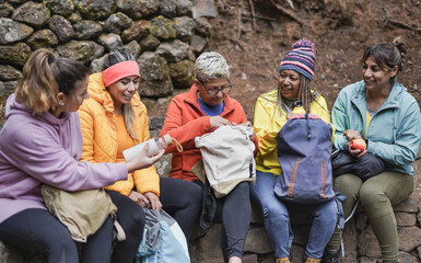  Multiracial women having a break during trekking day in the forest - Multi generational female friends enjoy day in nature