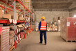 © New Africa - Man with tablet working at warehouse, back view. Logistics center