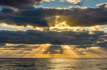 Sunrays And Golden Clouds Over Ocean At Sunrise