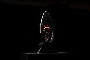 Wall Mural - glowing old vintage light bulb with black background