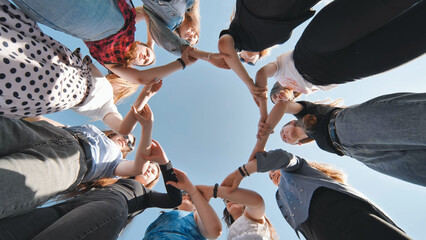 A group of girls makes a circle from their palms hands.