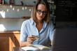 © ksenija1803z - portrait of woman sitting at table works with laptop and pay bank card in her hand