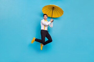 Wall Mural - Full body photo of excited satisfied person hold umbrella fly isolated on blue color background