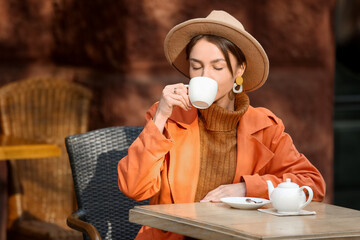 Wall Mural - Beautiful woman drinking tea in street cafe