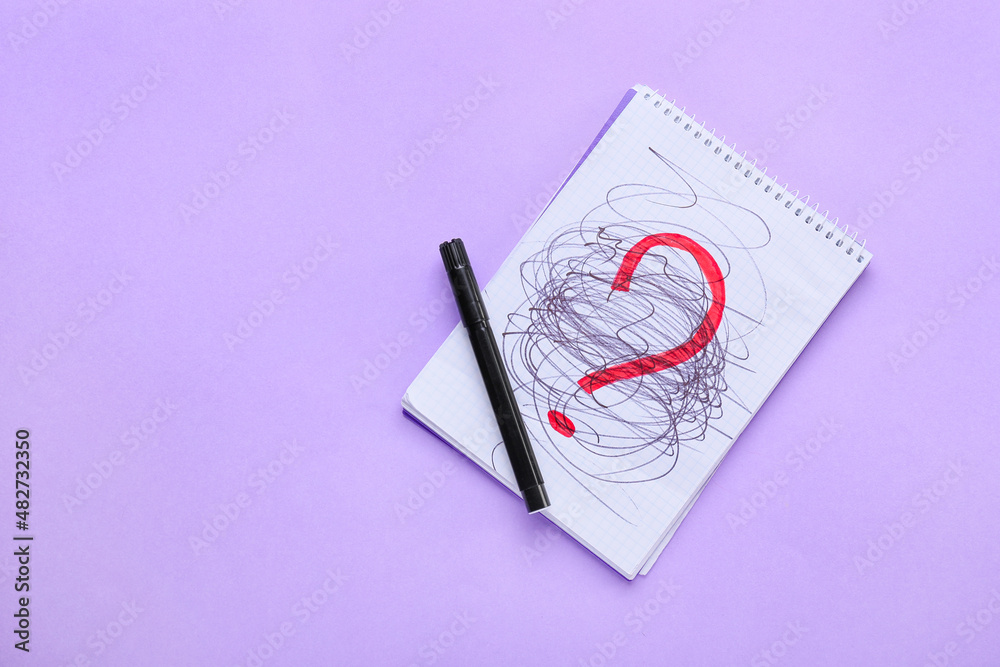 Notebook with question mark on purple background