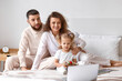 © Pixel-Shot - Happy young family with laptop in bedroom at home