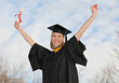 excited attractive graduate with diploma celebrating with arms stretched in the air