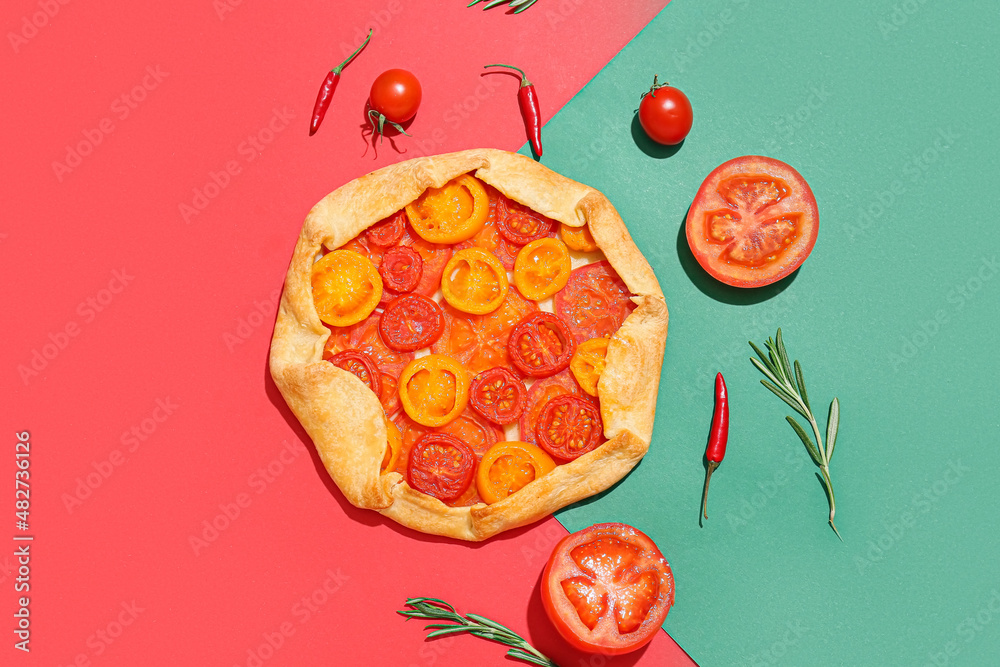 Tasty tomato galette and spices on color background
