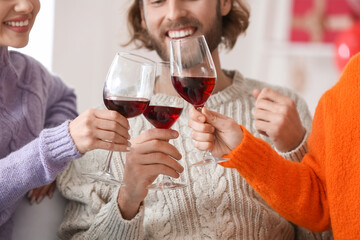 Man and two beautiful women drinking wine at home. Concept of polyamory