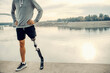 © dusanpetkovic1 - A fit sportsman with prosthetic leg standing at the quay with hands on hips. Proud handicapped man.