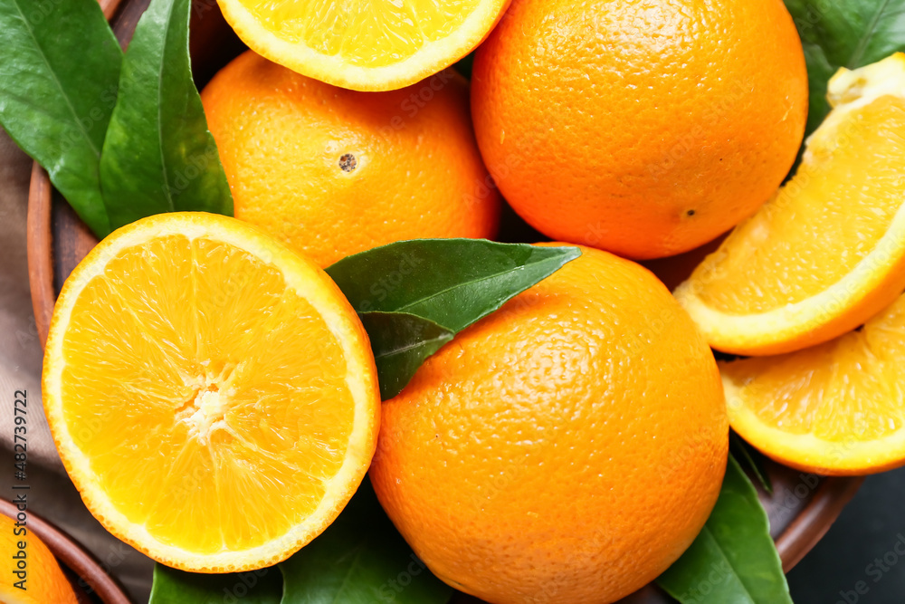 Bowl with fresh juicy oranges on table, closeup