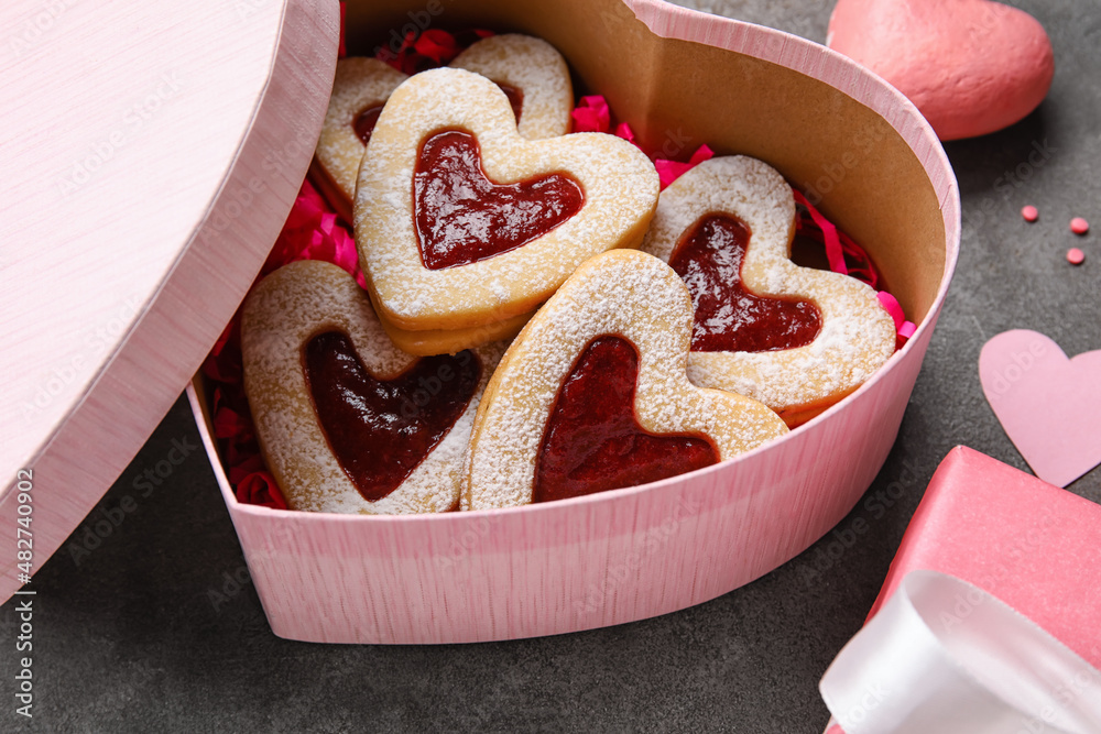 Box with tasty cookies in heart shape on grey grunge background