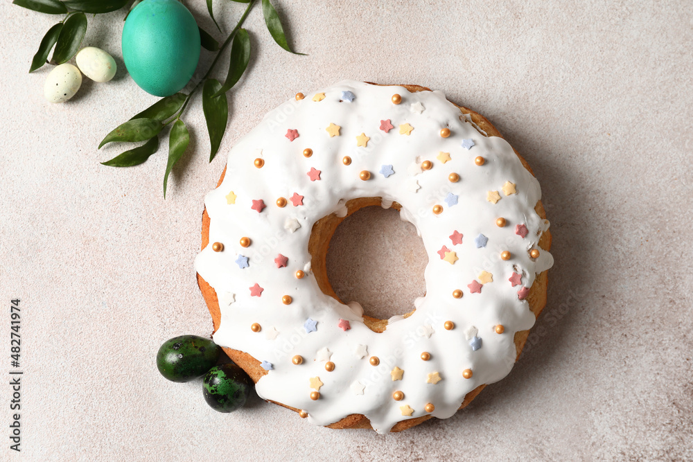 Tasty Easter cake and eggs on light background