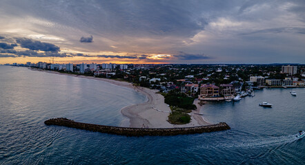 aerial drone of sunset over city with beach and ocean. clouds in sky with empty space. pompano beach