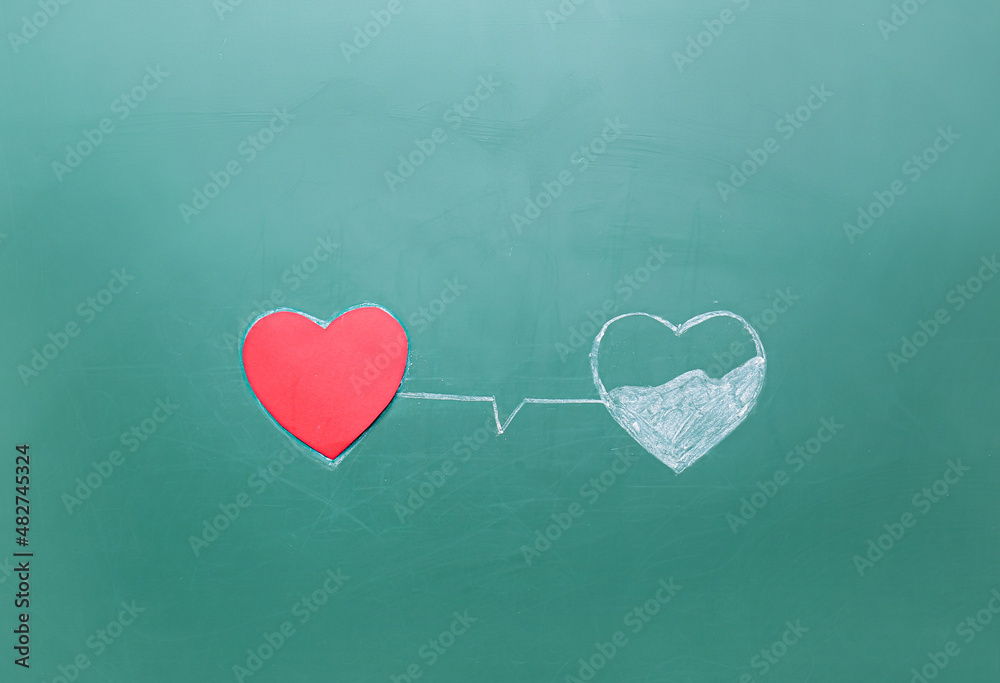 Red heart and chalk drawing on green background. Donation concept