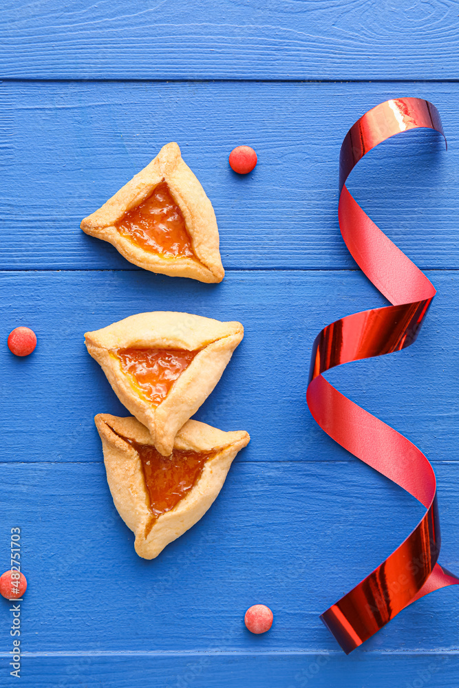 Hamantaschen cookies on color wooden background