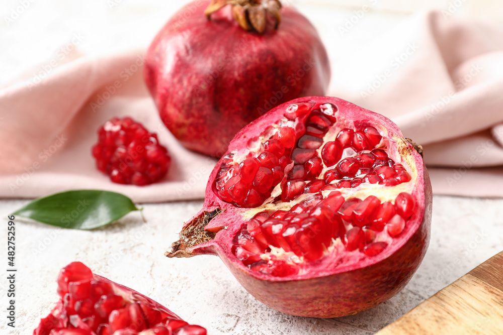 Ripe delicious pomegranate on light background, closeup