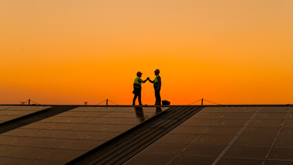 engineers walking on roof inspect and check solar cell panel by hold equipment box and radio communi