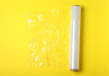 Roll Of Plastic Stretch Wrap Film On Yellow Background, Top View