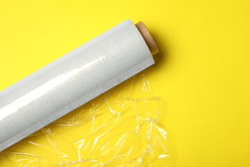 Canvas Print - Roll of plastic stretch wrap film on yellow background, top view