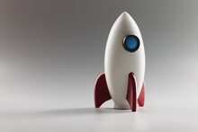 Miniature Rocket Toy Stand On Surface, Rocketship As Symbol For Business Project And Startup