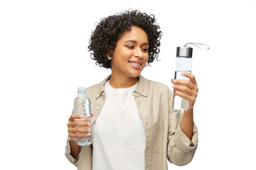 Wall Mural - eco living, zero waste and sustainability people concept - happy smiling woman with water in glass and plastic bottle over grey background