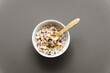 Frühstücksflocken mit Milch in einer weißen Schüssel auf einem braunen isolierten Hintergrund. Draufsicht, Frühstück.