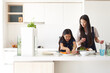 © Austockphoto - Mother and daughter preparing a meal together in kitchen