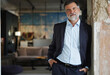 © opolja - Positive confident mature executive man smiling and looking at camera while standing in office