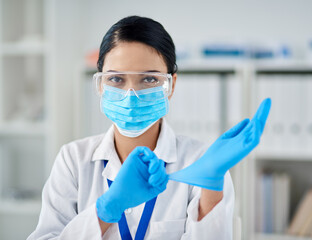 Poster - Let's get ready to science. Portrait of a confident young woman putting on surgical gloves in a laboratory.