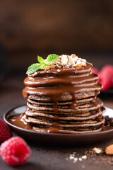 Wall Mural - Tasty Chocolate Pancakes With Chocolate Hazelnut Sauce Topping. Sweet Breakfast Pancakes Stack