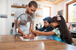© Chanelle Malambo/peopleimages.com - Let's wash those germs away. Cropped shot of a man and his two children washing their hands in the kitchen basin.
