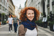Portrait shot of beautiful ginger woman tourist smiling in the city in front od St. Stephen Vasilica in Budapest, Hungary